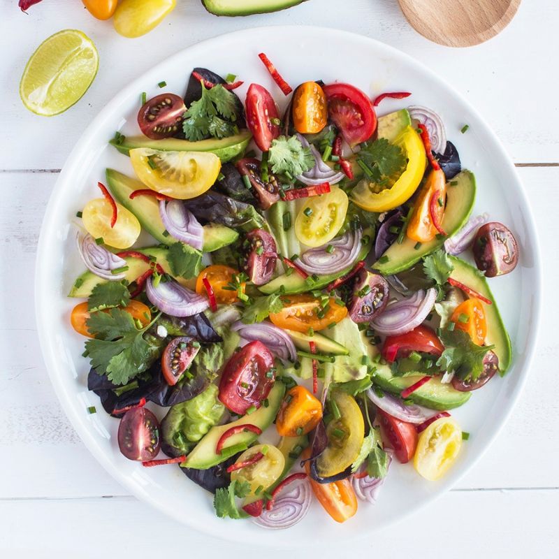 Tomato Avocado And Red Onion Salad With A Lime And Chilli Dressing.